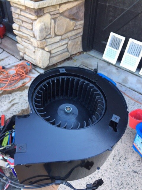 Blower motor assembly pulled out and cleaned on a driveway with tools and return grilles alongside